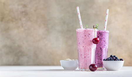 Cherry and blueberry smoothie in glass with straw. Healthy breakfast. Selective focus.の写真素材