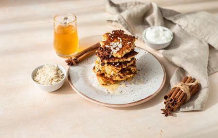 Stack of delicious apple pancakes or fritters with honey, spices and almond. Sunny morning. Autumn breakfast.の写真素材