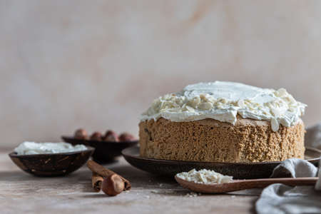 Homemade sponge cake or biscuit with nuts and spices decorated with butter cream or cream cheese icing. Selective focus.の写真素材