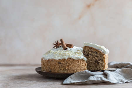 Homemade sponge cake or biscuit with nuts and spices decorated with butter cream or cream cheese icing. Selective focus.の写真素材