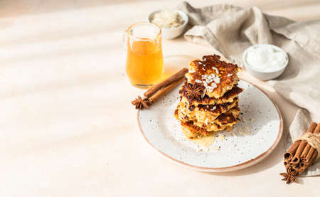 Stack of delicious apple pancakes or fritters with honey, spices and almond. Sunny morning. Autumn...