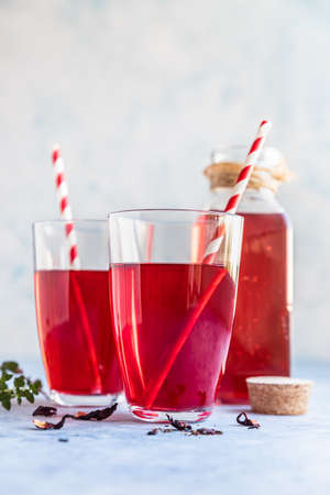 Hot hibiscus or karkade tea in glass with herb and dry tea leaves. Vitamin herbal tea for cold and flu.の写真素材