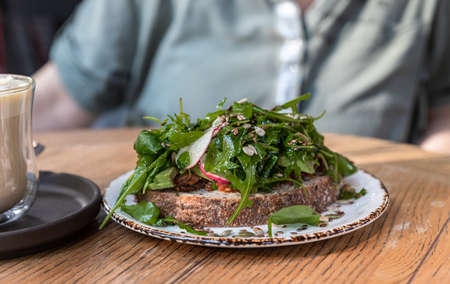 Artisan bread sandwich with arugula, radish and avocado salad. Vegan breakfast. Selective focus.の写真素材