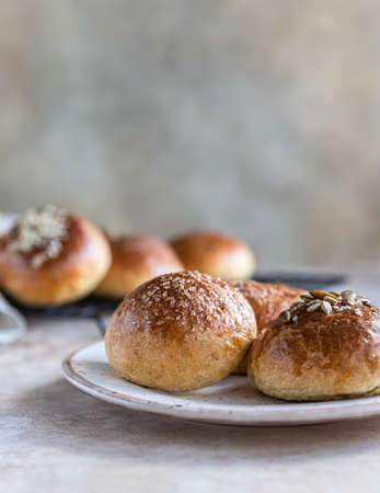 Fresh homemade pumpkin buns with brown sugar or seeds, light concrete background. Autumn bakery. Selective focus.の写真素材