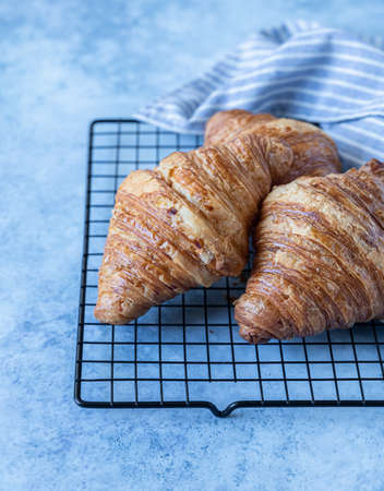Tasty crispy croissants, blue concrete background. Bakery for breakfast. Selective focus.の写真素材