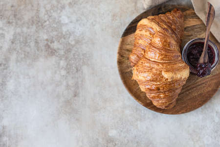 Fresh crispy croissants with jam, concrete background. Homemade bakery for tasty breakfast. Selective focus. Top view. Copy space.の写真素材