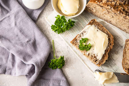 Freshly baked artisan multigrain bread with butter and pate. Breakfast with coffee, sliced bread, butter and liver pate. Light gray stone background.の写真素材
