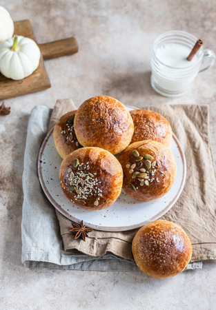 Fresh homemade pumpkin buns with brown sugar or seeds, light concrete background. Autumn bakery. Selective focus.の写真素材