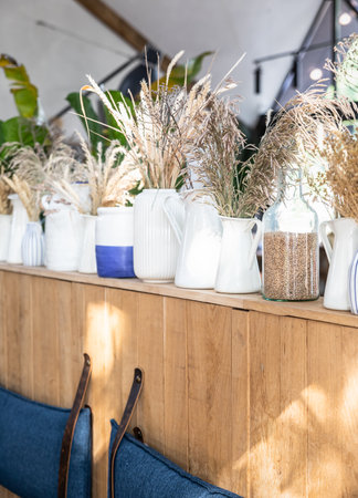 Different types of vases with wheat ears. Straws or dry plants. Eco interior concept. Minimalist...