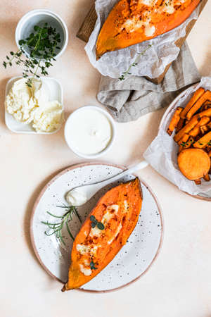 Baked sweet potatoes with mozzarella, herbs and creamy dip on concrete background. Top view.の写真素材