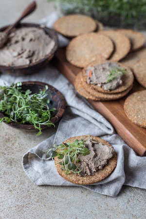 Homemade meat or chicken liver pate with multigrain crackers and microgreen, concrete background.の写真素材