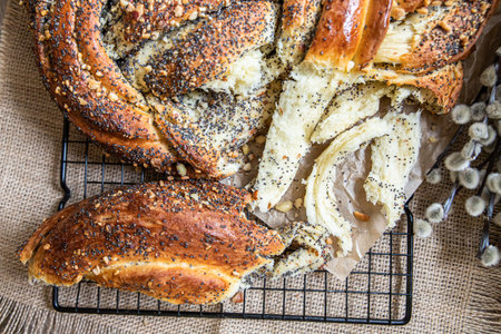 Easter twist bread with poppy seed and nut filling decorated with willow twigs and Easter eggs. Homemade babka or brioche bread.の写真素材