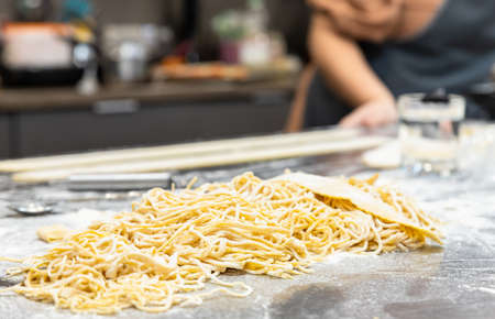 Raw homemade pasta on wooden cutting board. Uncooked fresh pasta.の写真素材