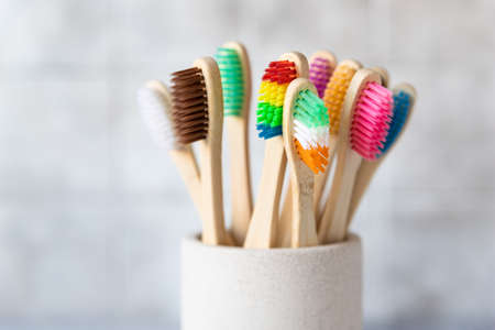 Colorful bamboo toothbrushes in cup. Organic wooden brushes. Zero waste, plastic free, eco friendly organic product concept. Close up.の写真素材