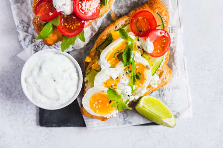 Variety of croissant sandwiches with tomato, cucumber, mozzarella cheese, eggs and mashed avocado...