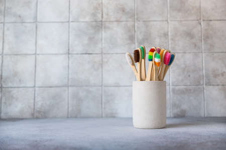 Colorful bamboo toothbrushes in cup. Organic wooden brushes. Zero waste, plastic free, eco friendly organic product concept.の写真素材