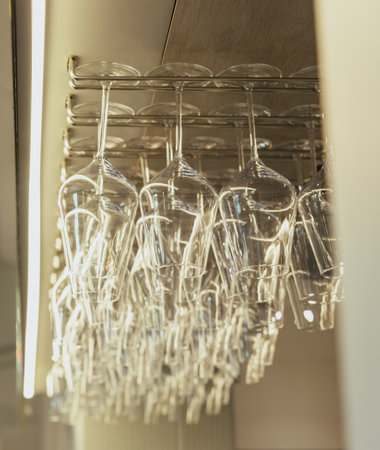 Glasses for wine. Glasses hanging above the bar in the restaurant. Empty glasses for alcohol or...
