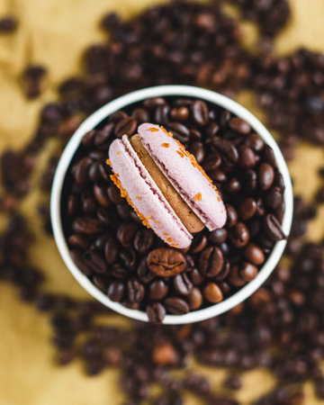 French or Italian macarons with coffee and vanilla filling and roasted coffee beans on brown background. food background. sweet food.の写真素材