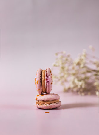 French or Italian macarons with coffee and vanilla filling, pink background. Dessert for tea or coffee break. food background. pastel color.の写真素材