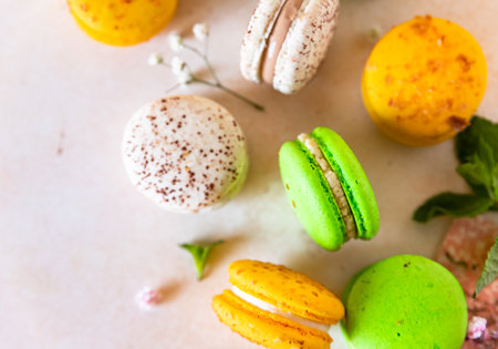 Colorful French or Italian macarons with lime, mint and flowers on light concrete background. Food sweet background.の写真素材