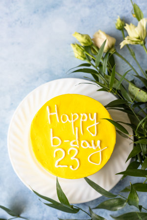 Small bento cake with inscription Happy b-day 23 as a gift for the birthday. Korean style cake for one person. A sweet surprise dessert for a loved one.の写真素材