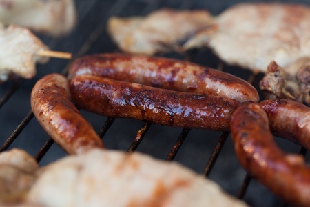 Several type of meats being cooked on a barbecueの写真素材