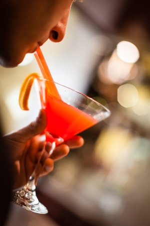 a distinguished young man holding a cocktail and celebratingの写真素材