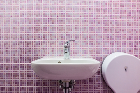 a clean white sink in a bathroon with pink tiled wallsの写真素材