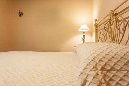 a luxurious bedroom with a lamp over a bed side tableの写真素材