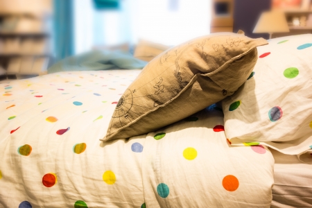 a comfortable bed with pillows and warm bedclothesの写真素材