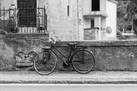 an old bicycle parked in a dirty italian alley wayの写真素材
