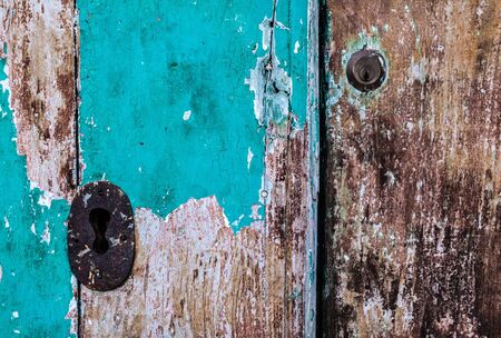 an old wooden and grungy locked door typical of the south of italyの写真素材