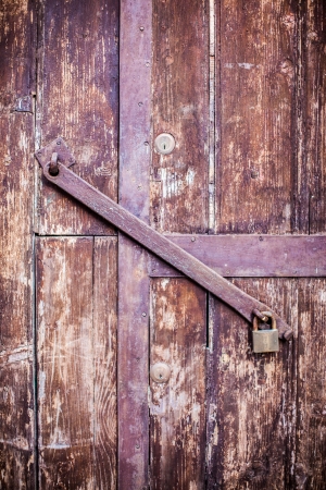 an old wooden and grungy locked door typical of the south of italyの写真素材