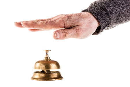 a mature old man ringing a hoted reception bell isolated over whiteの写真素材
