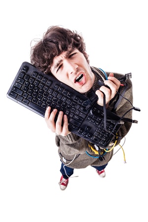 a casual guy with tangled cables and a keyboard struggeling to get computer assistance. isolated on whiteの写真素材
