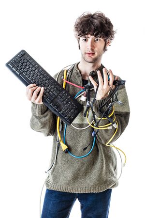 a casual guy with tangled cables and a keyboard struggeling to get computer assistance. isolated on whiteの写真素材