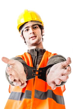 an engineer or a foreman wearing hard hat and reflective vest arrested with handcuffs isolated on whiteの写真素材