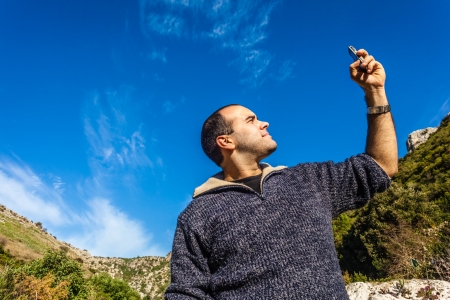 a man trying to pick up the signal on his mobile phone