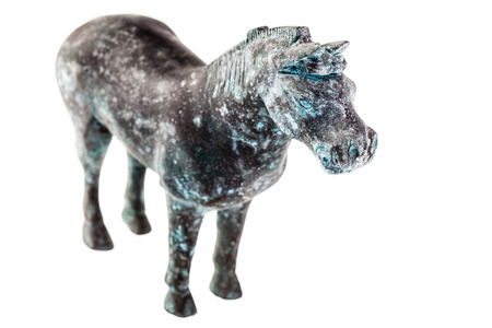 an ancient statuette depicting a horse isolated over a white backgroundの写真素材