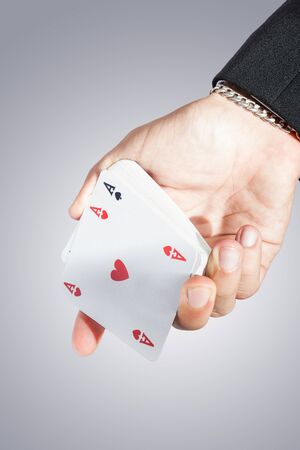 an elegant young businessman showing an ace of hearts in his hand