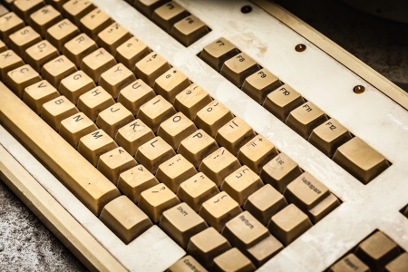 an old and yellowed dusty pc keyboard with stainsの写真素材