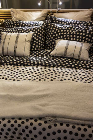 a cozy double bed with pillows and linenの写真素材