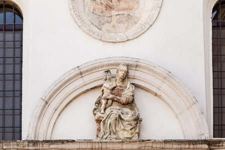 a statue of the holy virgin Mary on the facade of  a churchの写真素材