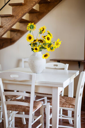 a bunch of vibrant potted sunflowers into a warm and cozy living roomの写真素材