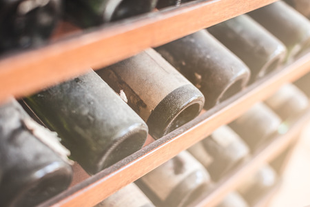 a lot of very old dusty wine bottles in an italian cellarの写真素材