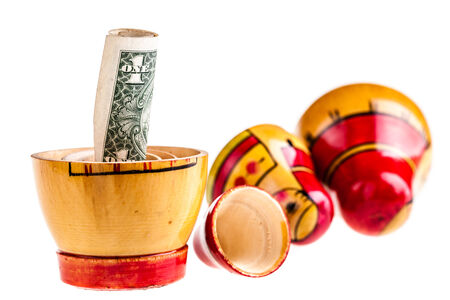 Russian doll with dollars inside isolated on white の写真素材