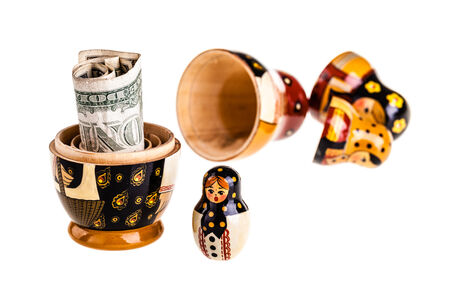 Russian doll with dollars inside isolated on white backgroundの写真素材