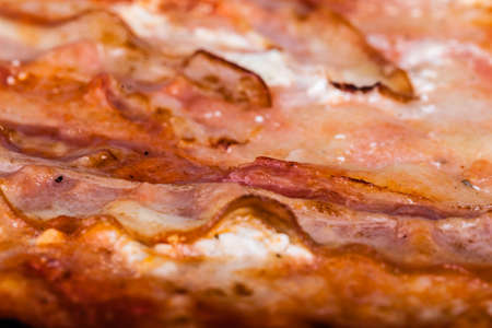 close up shot of a delicious pizza with speck and smoked cheeseの写真素材