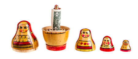 Russian doll with dollars inside isolated on white backgroundの写真素材