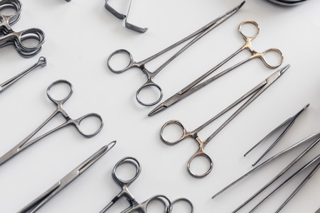 surgical instruments and tools including scalpels, forceps and tweezers arranged on a table for a surgeryの写真素材